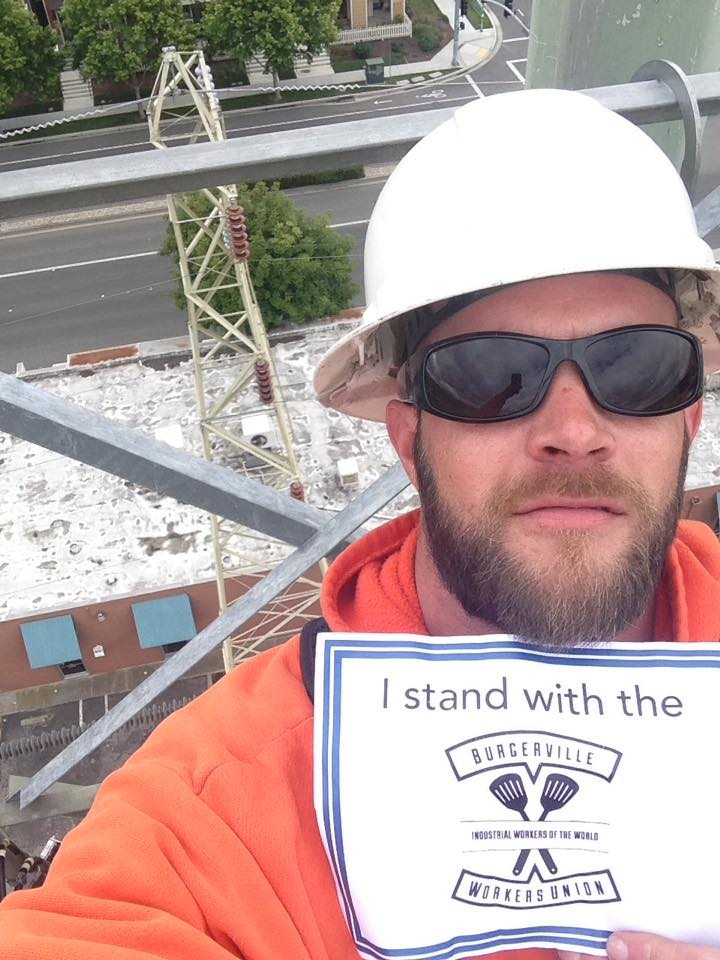 Cole Dorsey en lo alto de una torre eléctrica mostrando su solidaridad con los trabajadores del Sindicato de Burgerville.