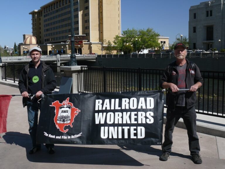 Railroad Workers United members holding a banner with their name and logo