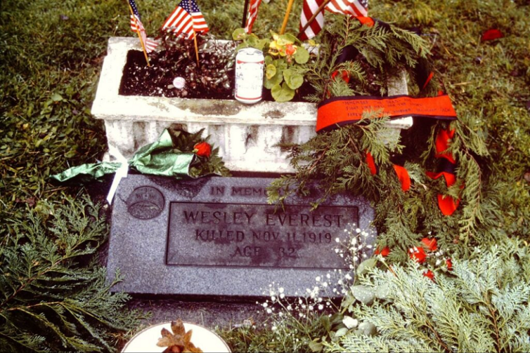 La tumba de Wesley Everest, decorado por banderas estadounidenses, flores, coronas de ramas de pino, y una lata de cerveza en la primera reunión anual de Wobblies en recuerdo de su muerte, 1989. Crédito de foto: FW Tuck x331980.